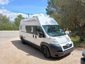 una furgoneta blanca estacionada en un estacionamiento en Furgoneta Camper Gran Volumen, en Palma de Mallorca