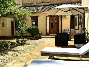 une terrasse avec un parasol en face d'une maison dans l'établissement Casa con vistas a la Alhambra y jardín privado, à Grenade