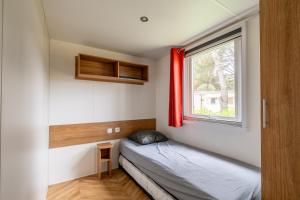 Habitación pequeña con cama y ventana en Mobil-home - Quiberon - vue sur mer en Quiberon