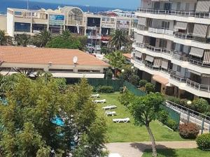 ein Park mit Liegestühlen in einer Stadt mit Gebäuden in der Unterkunft Jardines del Sur, 3 Bedroom in Los Cristianos