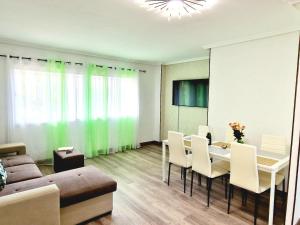 ein Wohnzimmer mit Tisch und Stühlen und einer Couch in der Unterkunft Jardines del Sur, 3 Bedroom in Los Cristianos