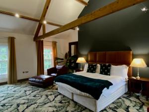 a large bedroom with a large bed and a couch at The Cawdor in Llandeilo
