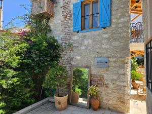 una casa de piedra con ventanas y plantas azules en Kuğu Urla, en Urla