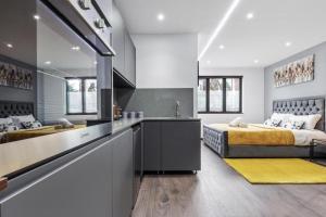 uma cozinha e um quarto com 2 camas num quarto em Serviced Golders Green Apartment near Camden London - 2 em Londres