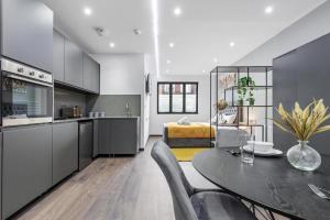 a kitchen and living room with a table and chairs at Serviced Golders Green Apartment near Camden London - 2 in London