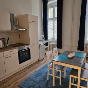 - une cuisine avec une table, une table et des chaises dans l'établissement Ferienwohnung Herbert-Jensch-Strasse 98, à Francfort-sur-l'Oder