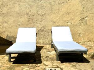 グラナダにあるCasa con vistas a la Alhambra y jardín privadoの壁の隣に座る空のベッド2台
