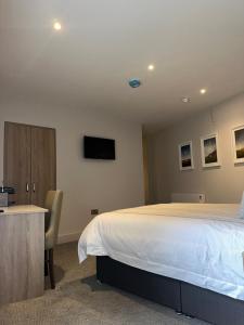 a bedroom with a bed and a desk and a television at Number One - Townhouse in Kinsale