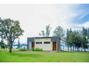 una pequeña casa en medio de un campo en Eben Lake Kivu cottages and Villas, 