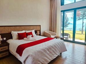 1 dormitorio con 1 cama grande con almohadas rojas en Eben Lake Kivu cottages and Villas, 