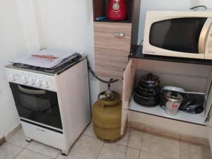 a small kitchen with a stove and a microwave at Apartamento próximo do centro in Vitória da Conquista