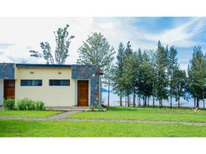 una pequeña casa en medio de un campo en Eben Lake Kivu cottages and Villas 