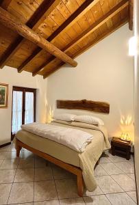 1 dormitorio con 1 cama en una habitación con techos de madera en Agriturismo La Vecchia Chioderia, en Grandola ed Uniti