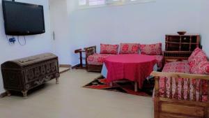ein Wohnzimmer mit einem Sofa und einem Tisch in der Unterkunft TIRIKA Hôtel La Gazelle in Zemmour Touirza
