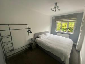 a white bedroom with a bed and a window at LT Apartments Stoneygate - 2 Bed in Leicester