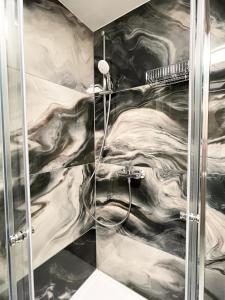 a bathroom with a shower with black and white marble at Hotel Löwenstein in Lich