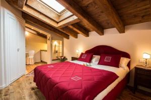 a bedroom with a large bed with red pillows at Casa Delneri Aquileia Adults Only in Aquiléia