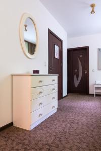 a bedroom with a dresser with a mirror and a door at Vila Pufu in Slănic-Moldova
