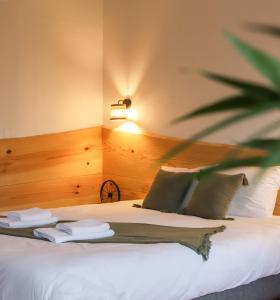 a hotel room with a bed with white sheets and pillows at Maison Tournesol in Gan
