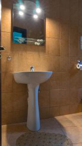 W łazience znajduje się biała umywalka i lustro. w obiekcie Vila Pufu w mieście Slănic-Moldova