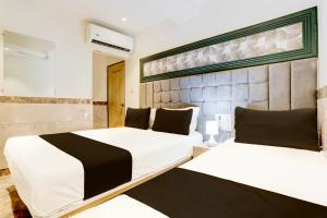 duas camas num quarto com branco e preto em OYO Hotel Diamond Residency em Mumbai