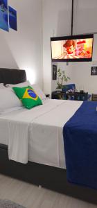 1 dormitorio con 1 cama y TV en la pared en Copacabana Vibes Hub en Río de Janeiro
