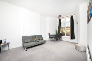 a living room with a couch and a table at Spacious minimalist 1BR flat in London in London