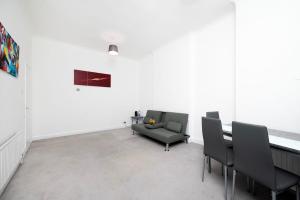a living room with a couch and a table and chairs at Spacious minimalist 1BR flat in London in London