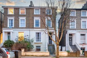 a large brick house with a tree in front of it at Spacious minimalist 1BR flat in London in London