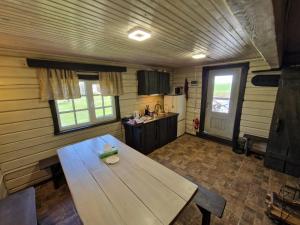 eine Küche mit einem Holztisch im Zimmer in der Unterkunft Bajāri - Pirts - Banya in Svente
