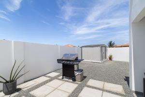 a backyard with a grill and a fence at Tanki Leendert 43K in Oranjestad