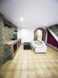 sala de estar con sofá y chimenea de piedra en Casa Castillo de Santiago Barbate, en Barbate