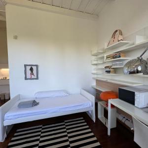 Habitación blanca con cama y estante en Cascina Torriggio Estates, en Rozzano