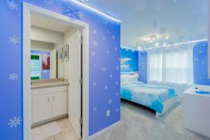 ein blaues Schlafzimmer mit einem Bett, einer Badewanne und einem Waschbecken in der Unterkunft No Airbnb Fee 2199 Luxury House in Kissimmee