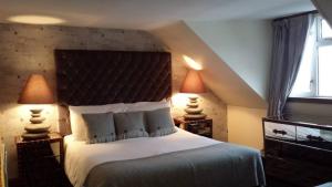 a bedroom with a large bed and a large window at The Tobermory Hotel in Tobermory