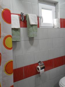 uma casa de banho com um WC, uma janela e toalhas em Ravne Konak em Visoko