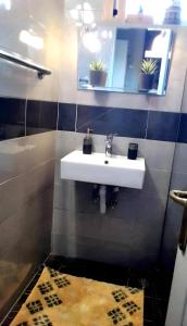 a bathroom with a sink and a mirror and a rug at Mina's Veranda 90 sqm in Patra