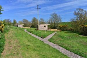 a stone path leading to a small building in a field at Anniston Mill Cabin 1 in Arbroath