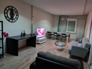 a living room with a couch and a tv at Maison de 3 chambres avec jardin clos et wifi a Merignac in Mérignac
