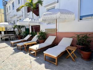 un grupo de sillas y sombrillas en un patio en La Mona Suites - Cozy 1 BR with Full Kitchen, en San Juan