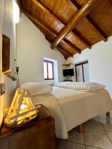 a bedroom with a large bed and wooden ceilings at Agriturismo La Vecchia Chioderia in Grandola ed Uniti