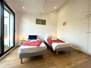 a bedroom with two beds and a large window at Villa L'Alameda Spa Billard Paris Centre 35min in Verrières-le-Buisson