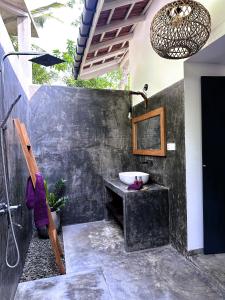 uma casa de banho com um lavatório e um espelho em Ebony Boutique Villa em Ahangama
