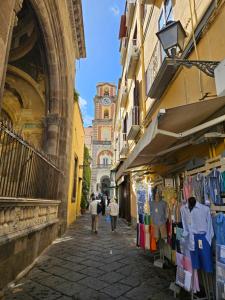 Un gruppo di persone che camminano per strada con un mercato di Casa savoia dream a Napoli