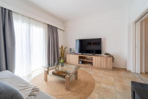 een woonkamer met een tv en een salontafel bij Residence City Apartment in Rhodos-stad