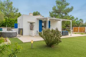a white house with blue doors and a yard at Sestanyol in Colonia de Sant Pere