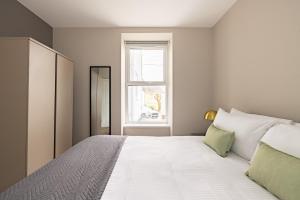 a bedroom with a large white bed with a window at Charles Hope Plymouth in Plymouth