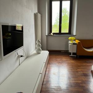 uma sala de estar com uma televisão na parede em Cascina Torriggio Estates em Rozzano