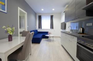 a kitchen and living room with a blue couch at Split Urban Getaway in Split