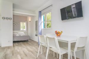 a white dining room with a white table and chairs at Sestanyol in Colonia de Sant Pere